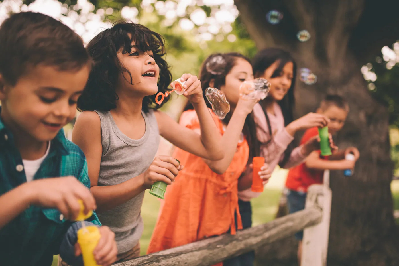 Children blowing bubbles together outdoors